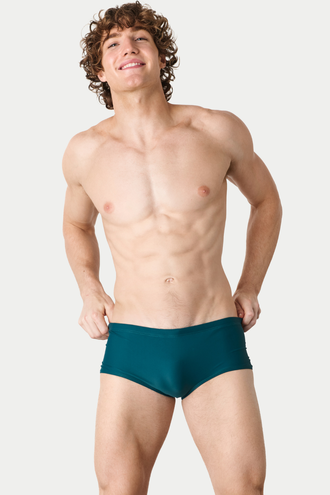 Man wearing teal swim briefs with solid color and fitted cut.