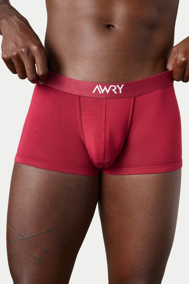 A close-up of a male model wearing red boxer briefs with the brand name &