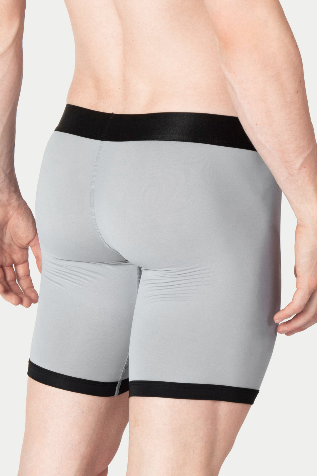 Gray boxer briefs with black elastic waistband and leg cuffs, shown on model from waist down.