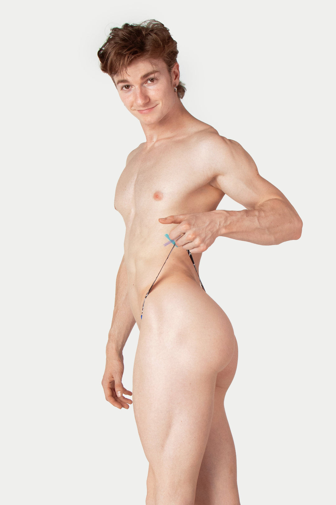 Man wearing cobalt blue thong with drawstring waistband, shown from the side.