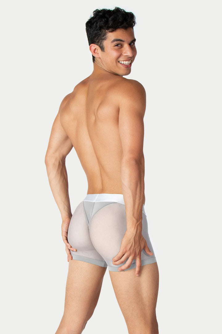 Man wearing silver and white thong trunks with white waistband, shown from behind.