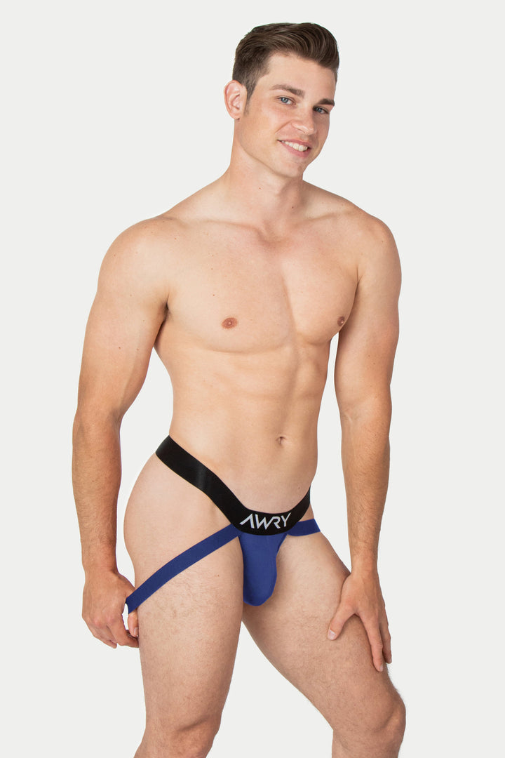 Navy jockstrap with black waistband and "AWRY" branding, shown on male model.