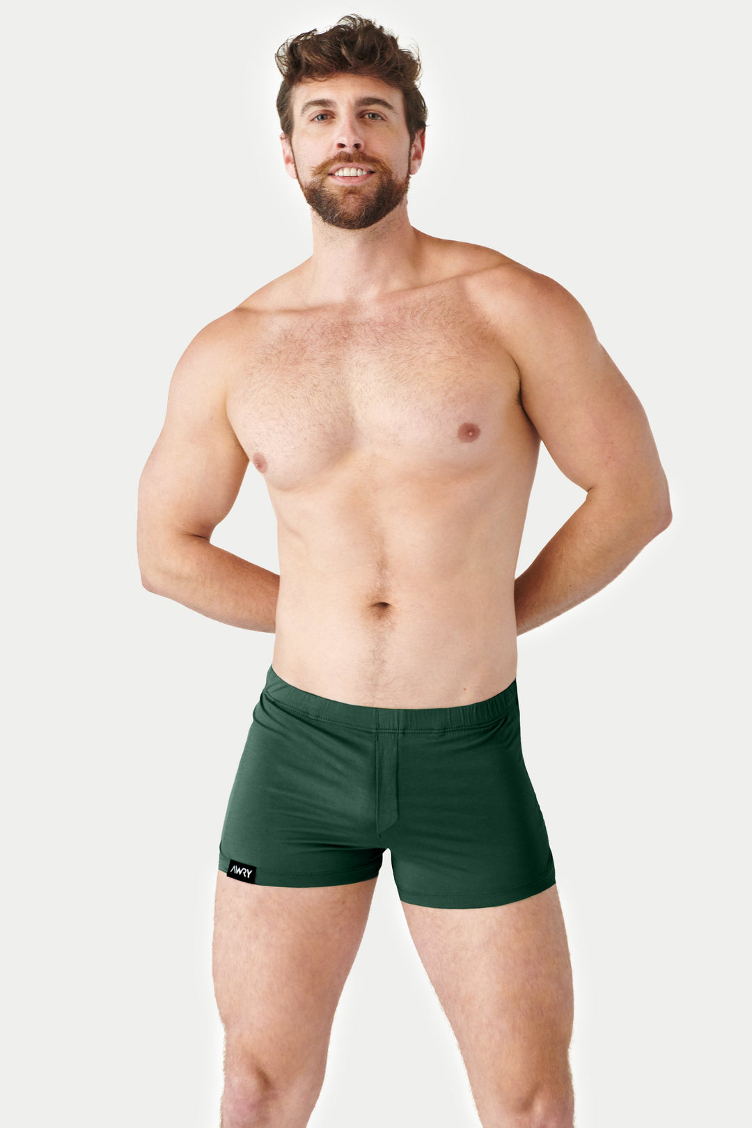 Man wearing pine green jock boxers with elastic waistband and brand label on leg.