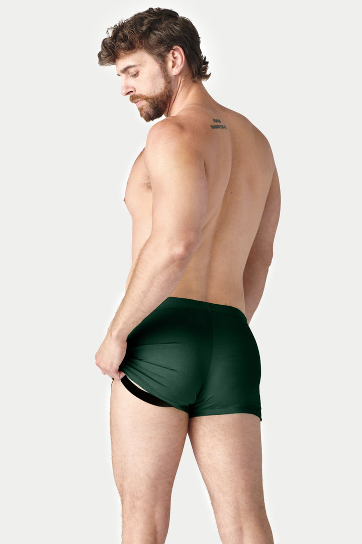 Pine green jock boxers with black trim shown from side view on male model.