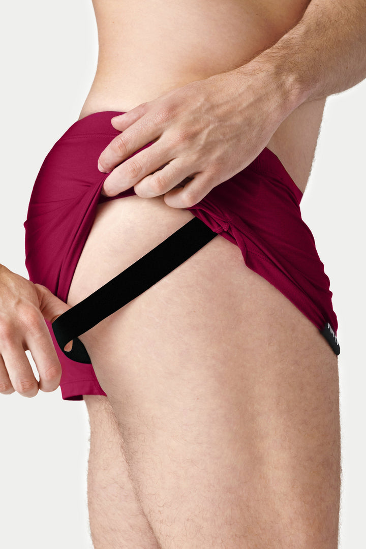Berry red jock boxers with black supportive pouch and waistband shown on model.