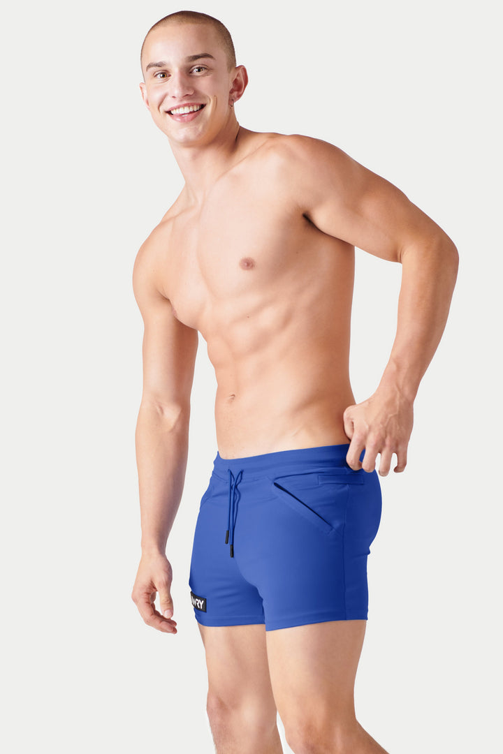 Cobalt blue shorts with drawstring waist and side branding, worn by male model.