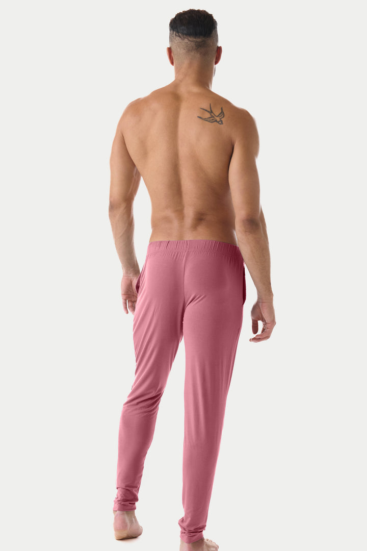 Man wearing blush red lounge pants with elastic waistband, shown from behind.