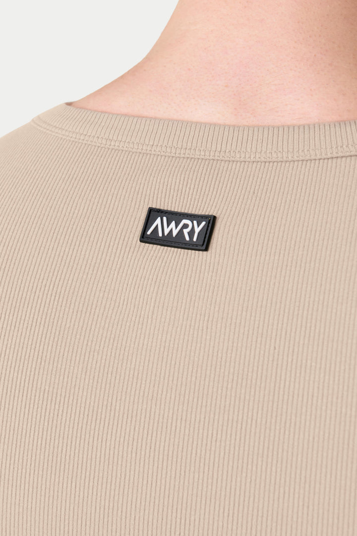 Sand-colored ribbed tank top with crew neckline and black brand label on chest.