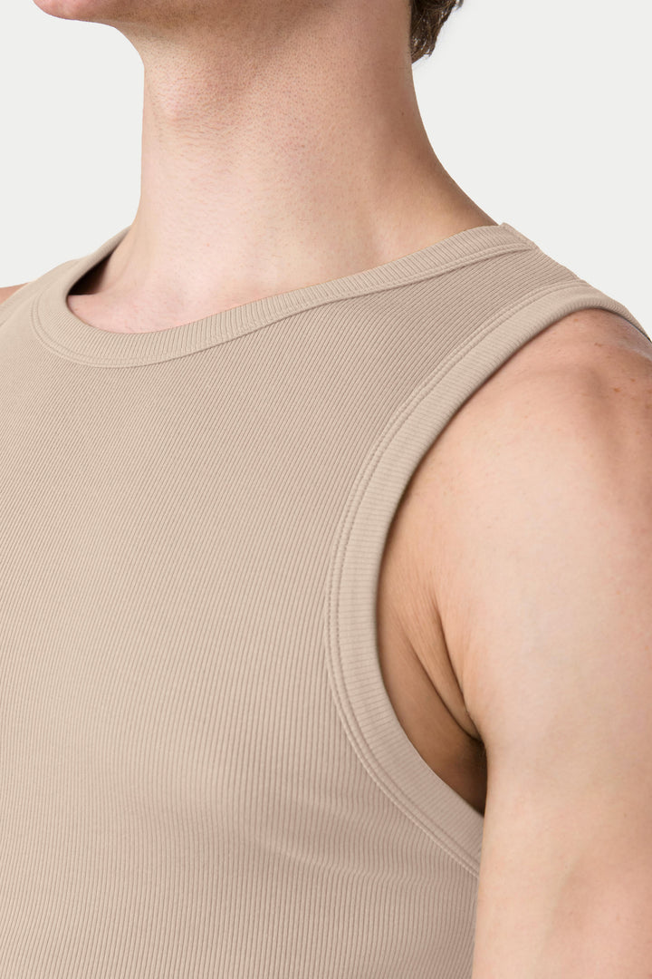 Sand-colored ribbed tank top with crew neckline worn by person shown from shoulders up.