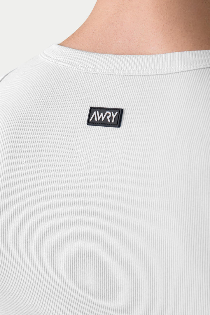 White ribbed tank top with crew neckline and small black brand label on chest.
