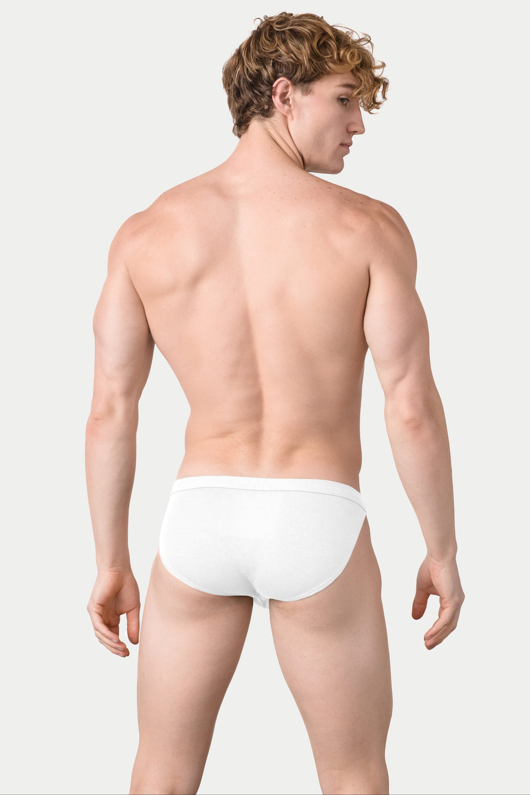White ribbed tanga briefs with textured fabric, shown from back view on model.