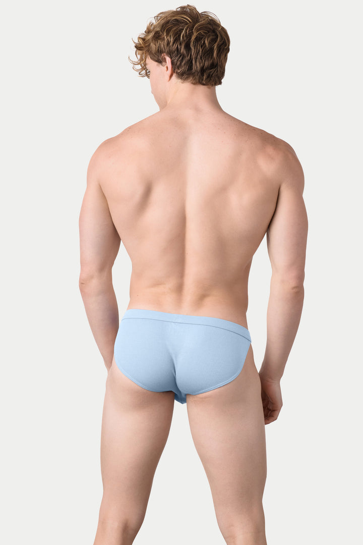 Man wearing sky blue ribbed tanga briefs, rear view.
