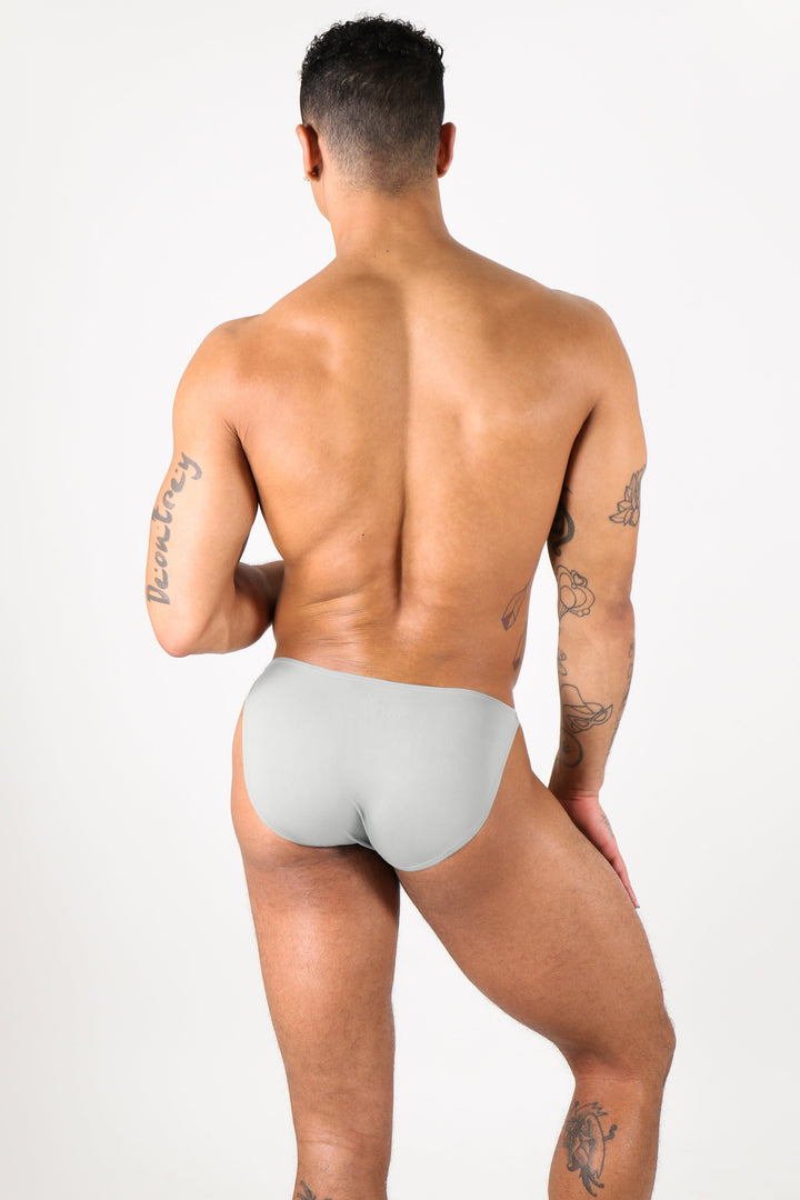 Light gray bikini briefs on male model shown from back view against white background.